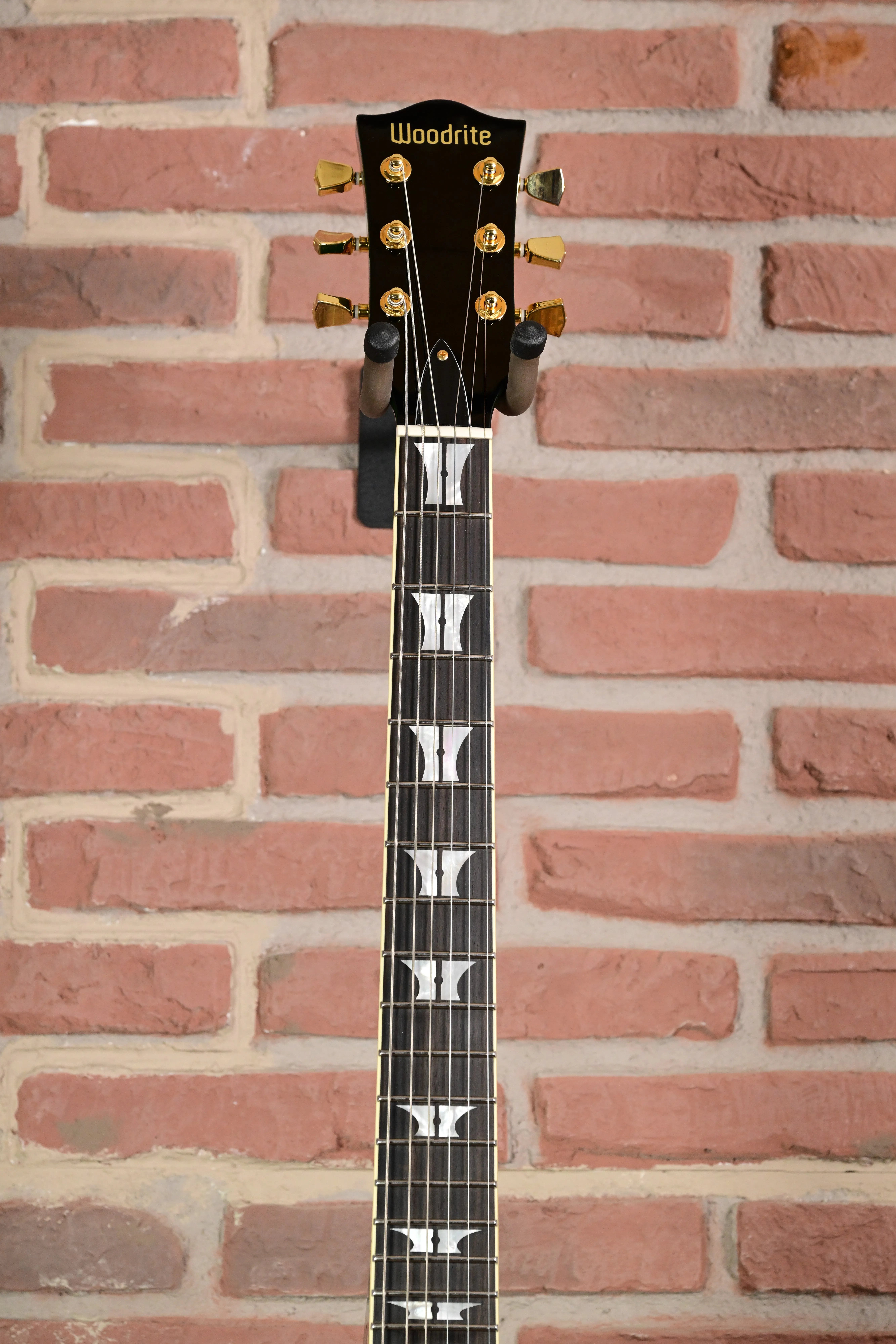 Gitarre, schwarzes Griffbrett, goldfarbene Mechaniken, weiße Griffbretteinlagen, sechs Saiten