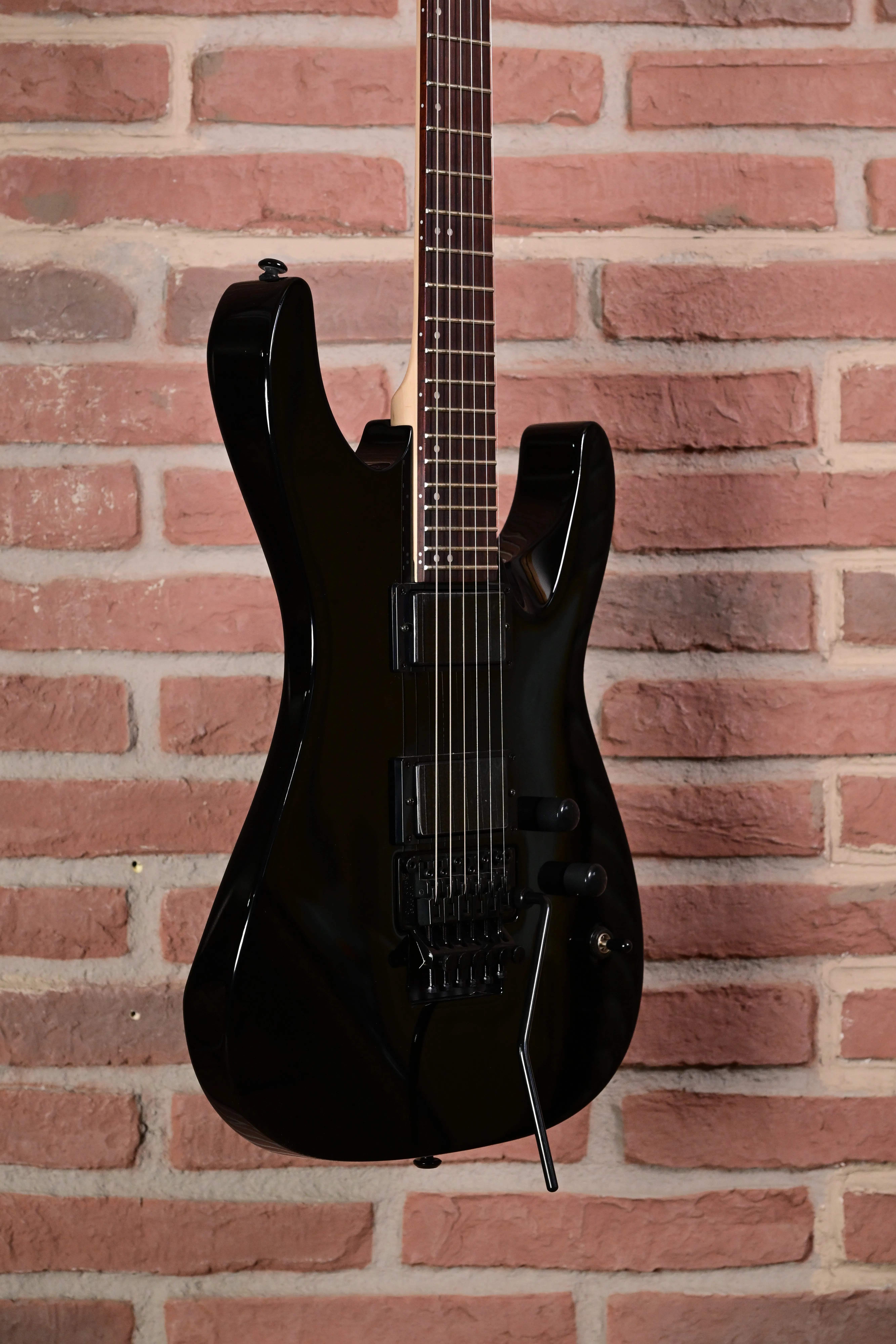 E-Gitarre, schwarzer Korpus, sechs Saiten, Doppelspulen-Tonabnehmer, Tremolohebel
