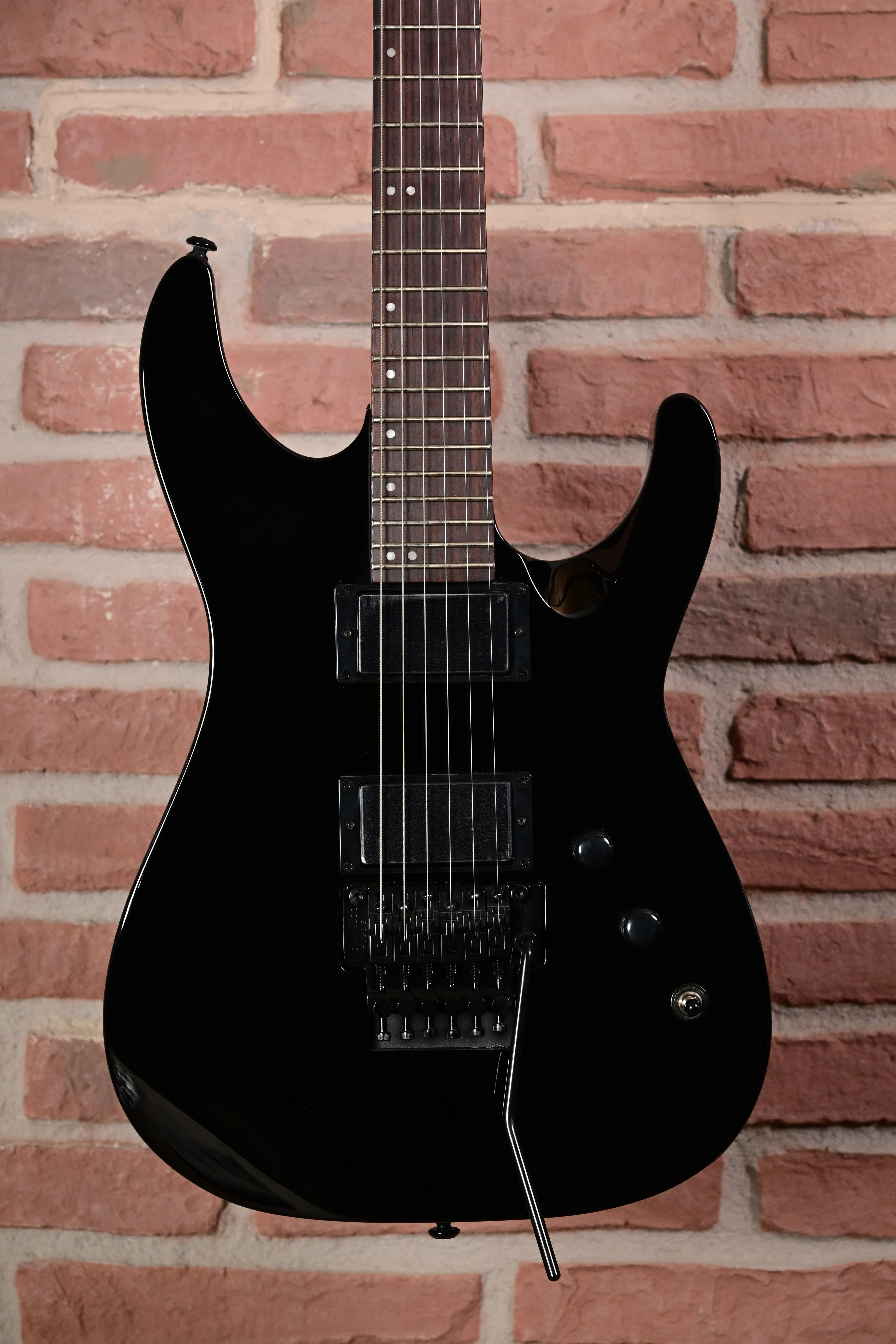 E-Gitarre, schwarzer Korpus, Doppelspulen-Tonabnehmer, Tremolo-System, sechs Saiten