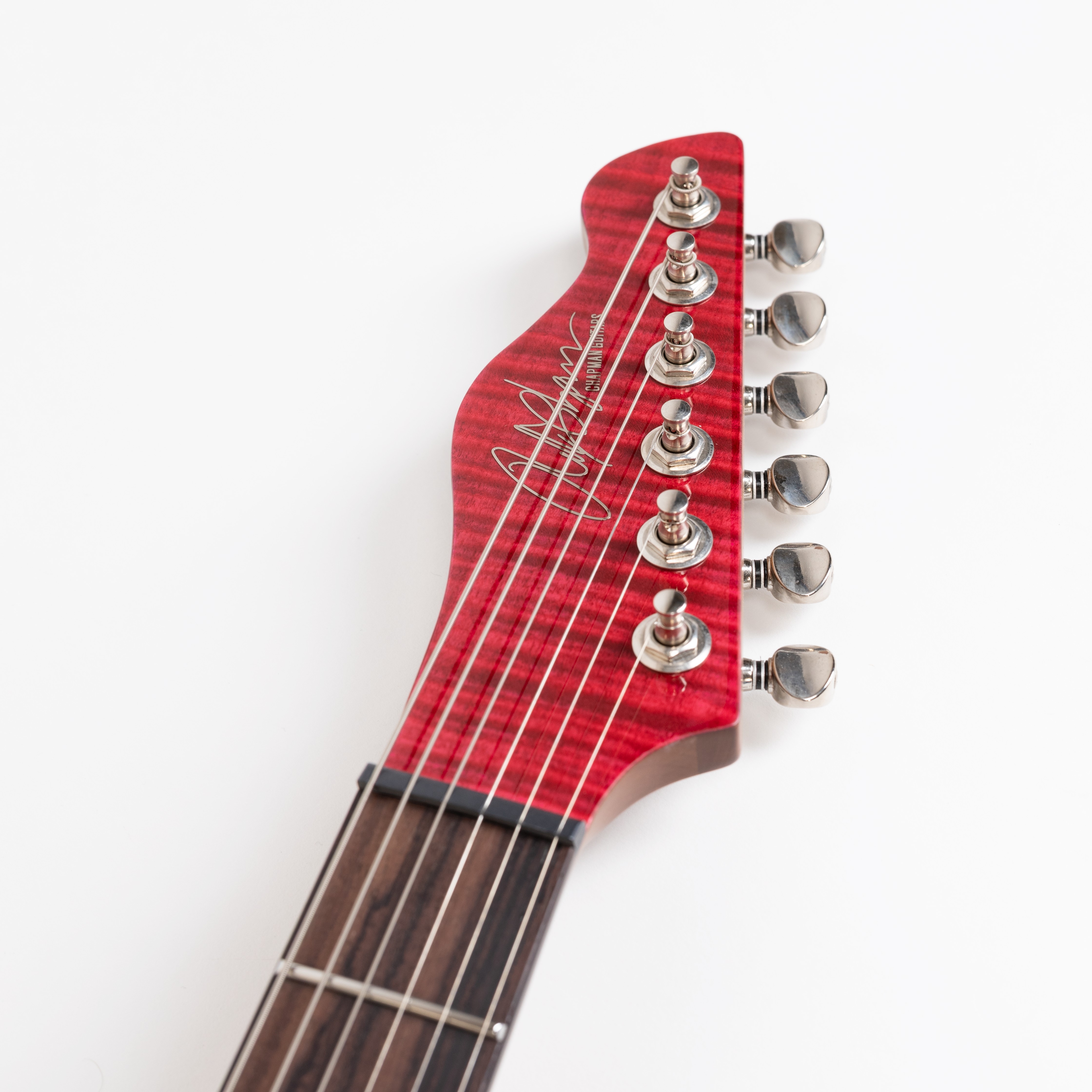 E-Gitarren-Kopfplatte, rote Maserung, sechs Saiten, Stimmmechaniken, dunkles Griffbrett