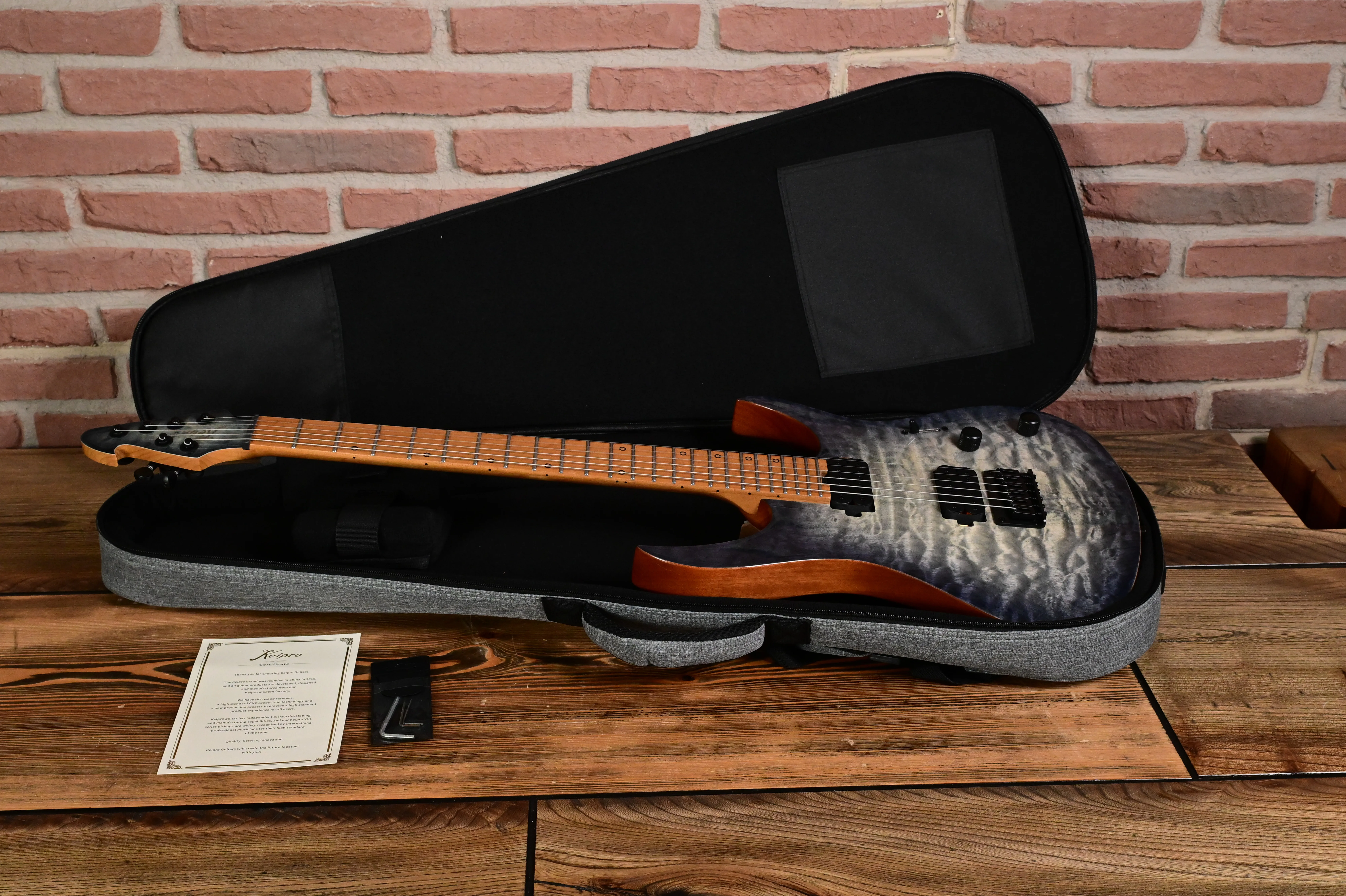 E-Gitarre, Gitarrenkoffer, grau-schwarzer Korpus, gemaserte Decke, Ahornhals