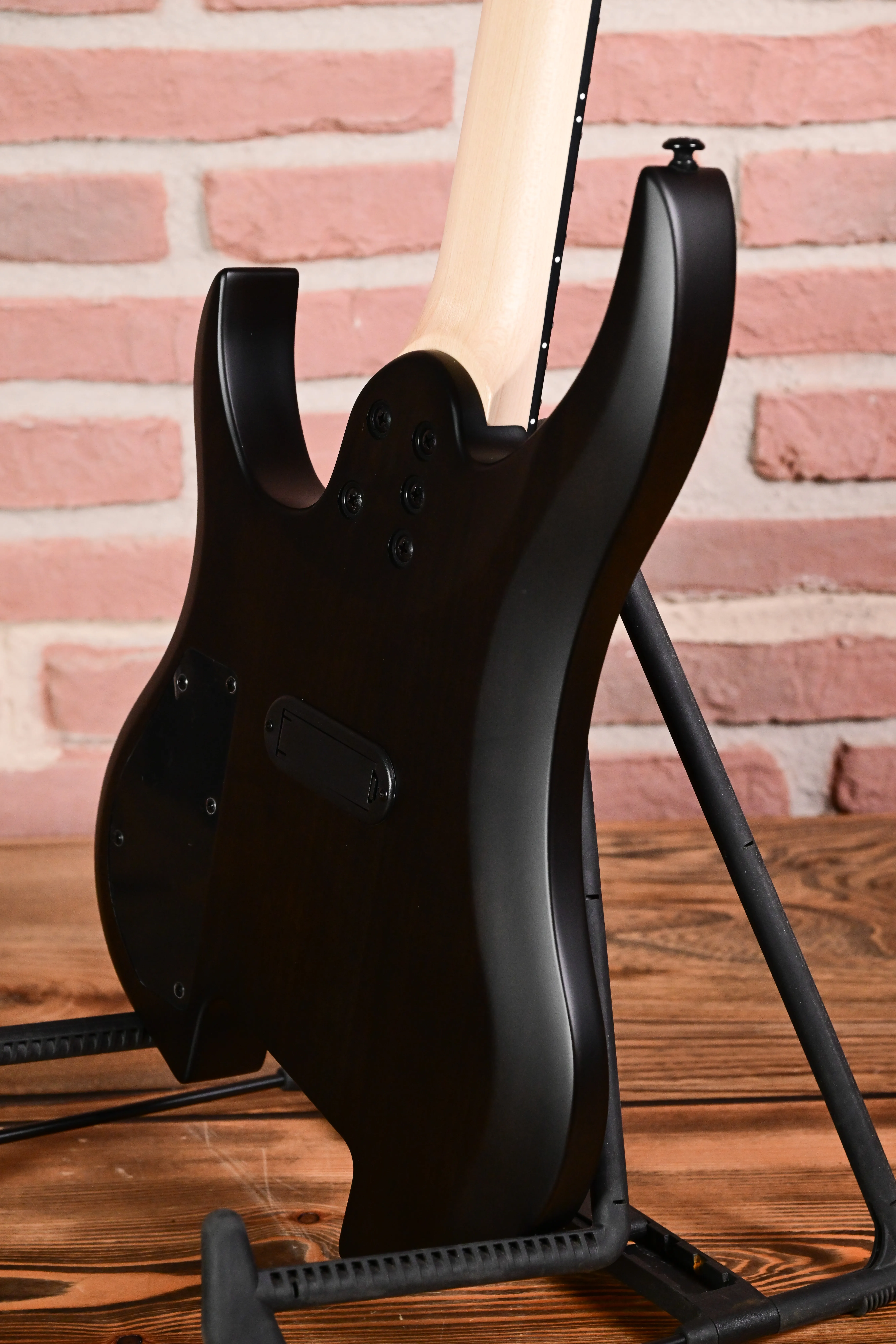 E-Gitarre, schwarzer Korpus, mattes Finish, Ahornhals, Gitarrenständer