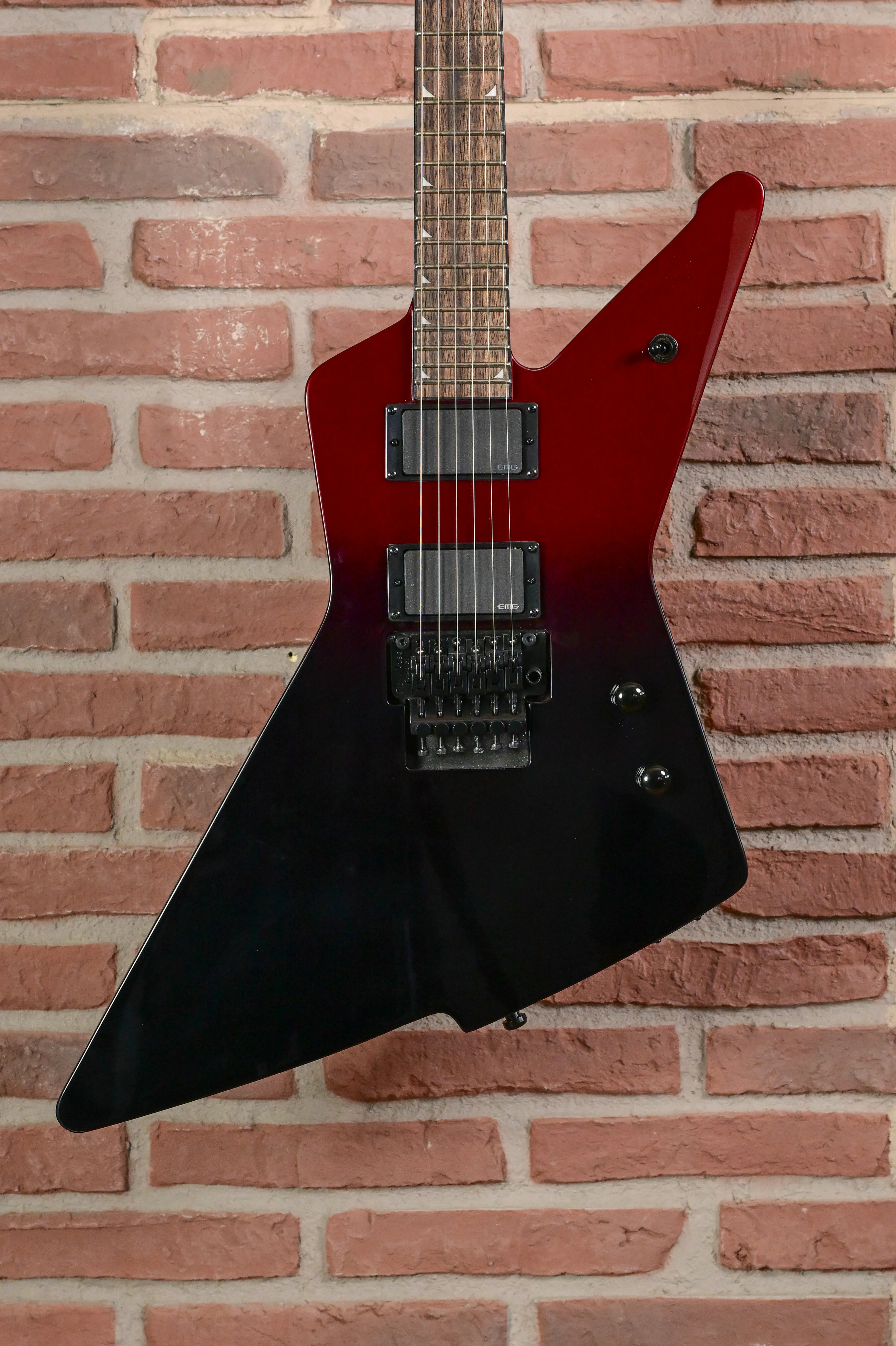 E-Gitarre, Flying-V-Form, Rot-schwarzer Korpus, Doppelspulen-Tonabnehmer, Tremolo-System