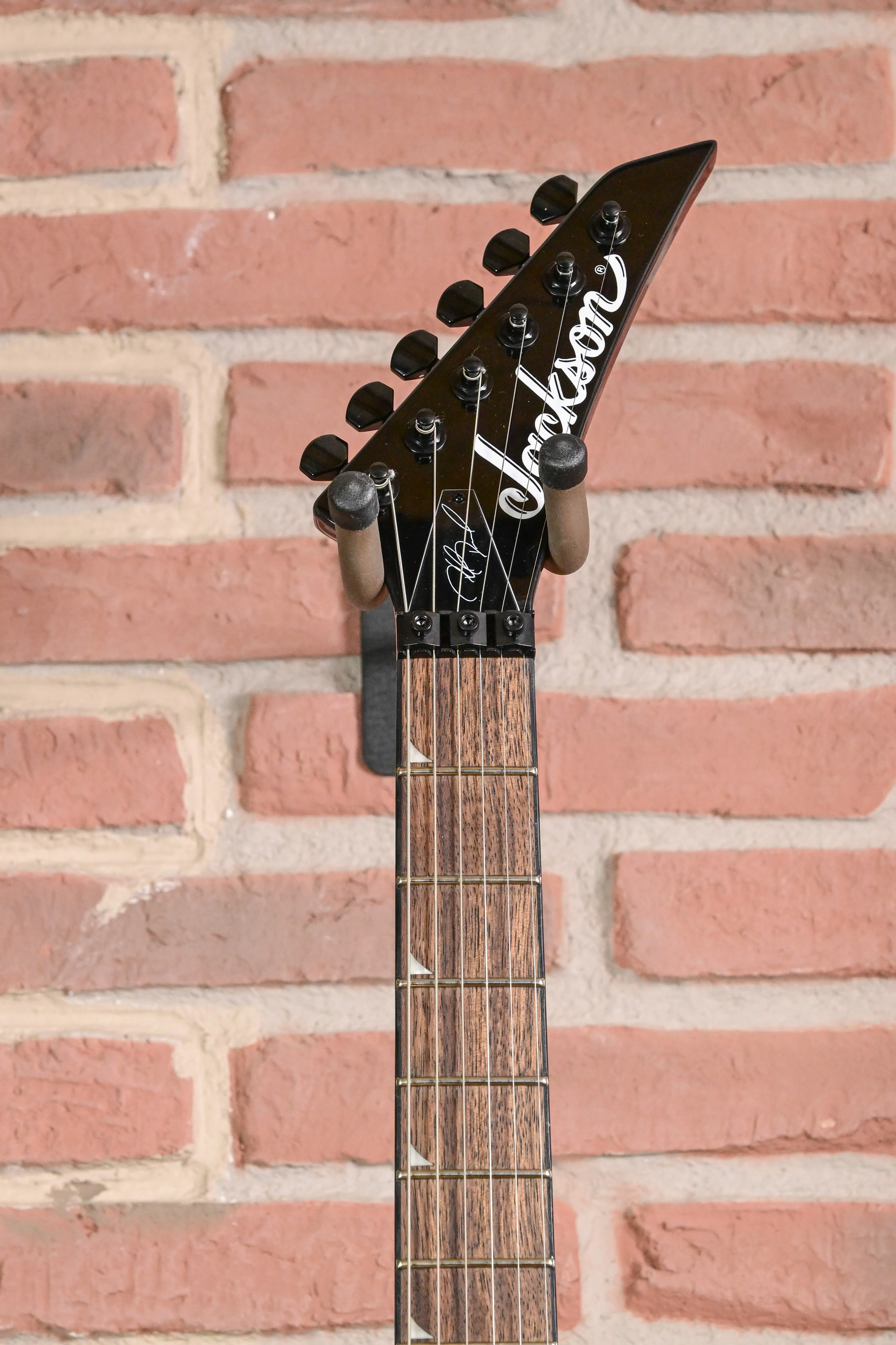 E-Gitarre, schwarzer Gitarrenkopf, spitze Kopfplatte, Holzgriffbrett, sechs Saiten
