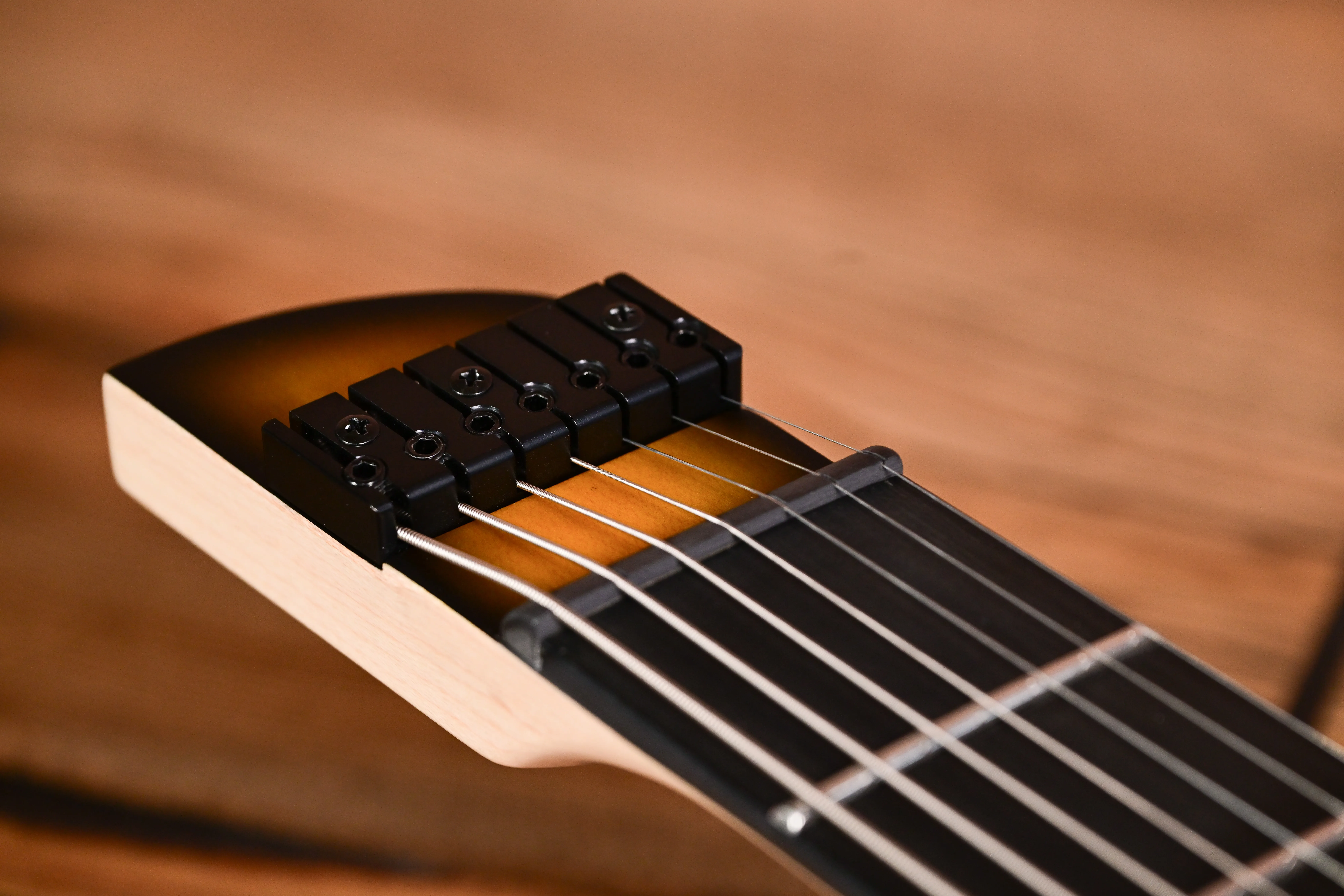 E-Gitarre, Gitarrensteg, schwarze Saitenreiter, helle Holzseite, sechs Saiten